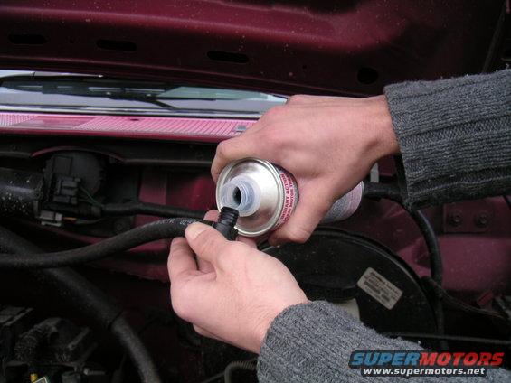 1994 Ford Bronco engine bay, pouring fluid into hose