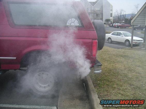Red SUV with a spare tire on the back, emitting white smoke from the exhaust. Visible sticker says "BRONCO OFF ROAD 4X4"