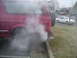 1994 Ford Bronco - A red SUV, possibly a Ford Bronco, emits a large cloud of smoke from its exhaust pipe.
