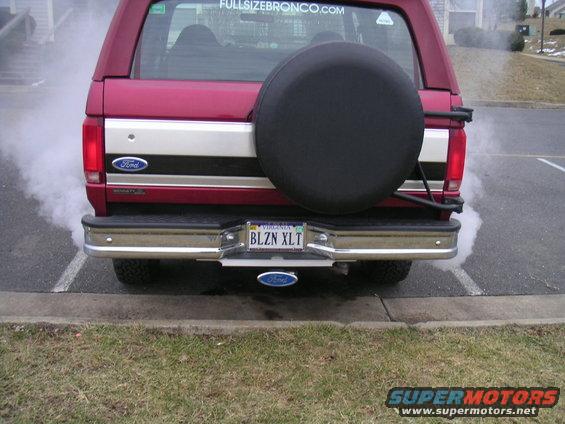 Red 1994 Ford Bronco rear view with smoke from exhaust