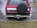 1994 Ford Bronco - A red 1994 Ford Bronco is seen from the rear, emitting smoke from its exhaust pipe.