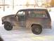 1985 Ford Bronco - This Ford Bronco is seen from the side, covered in dirt and parked in a snowy landscape.