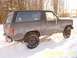 1985 Ford Bronco - This Ford Bronco is seen from the side in a snowy environment, with the rear tire spinning.