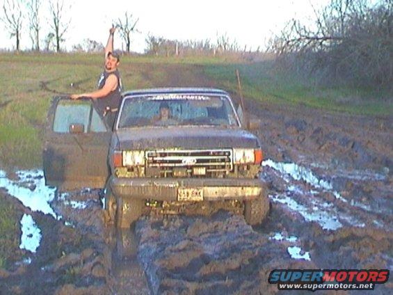 1989 Ford Bronco stuck in mud, driver giving thumbs up