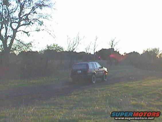 Dark SUV in a field, 3q-front view