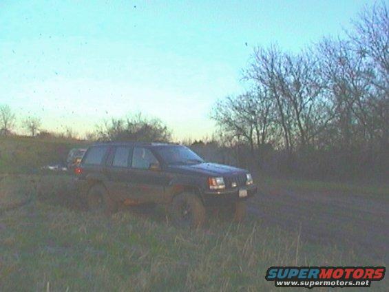 Jeep Grand Cherokee stuck in mud with another vehicle behind it