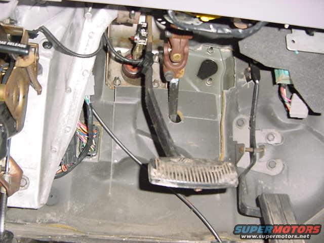 Interior footwell with brake and gas pedals, wiring visible