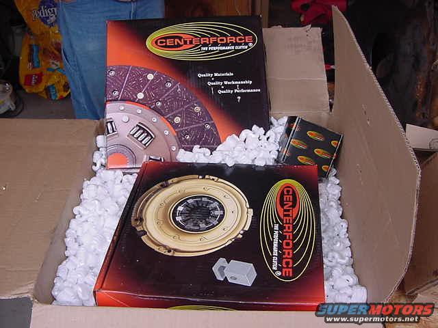 Boxes of Centerforce performance clutch parts, including a pressure plate and clutch disc, packed in white foam peanuts