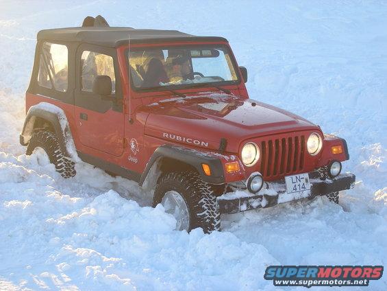 Red 2001 Jeep TJ Rubicon stuck in deep snow, front view