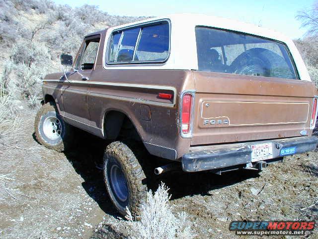 Brown 1978 Ford Bronco rear 3/4 view on dirt trail