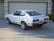 1978 Ford Mustang II - The rear of a white 1978 Ford Mustang II shows a custom spoiler and a license plate reading 'COBRA 78'.