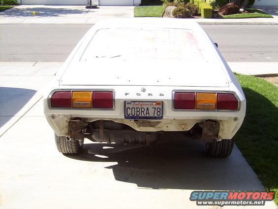 White Ford Cobra 78 with California license plate, rear view, bumper removed, in driveway
