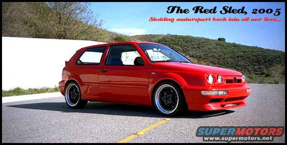 Red Volkswagen Golf Mk3 with black aftermarket wheels, parked on asphalt. Front bumper and headlights visible