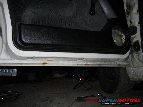 Interior door panel and lower door frame with rust spots. A speaker is visible in the door