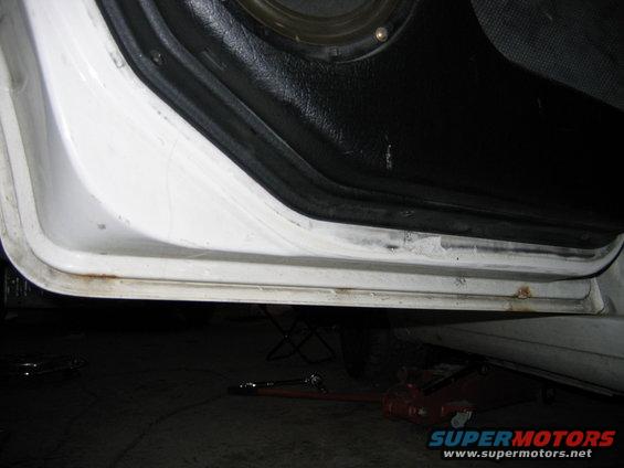 Close-up of a car's interior door sill with some rust visible