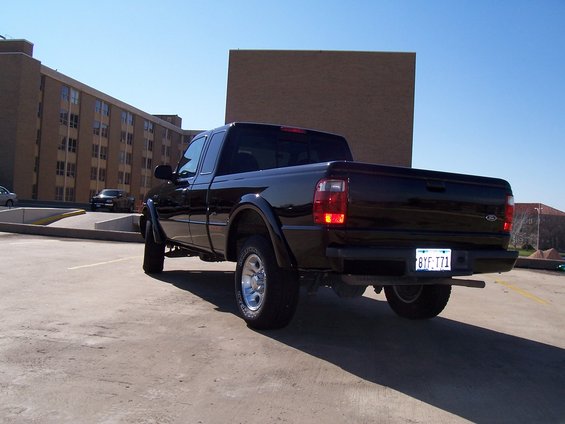 Black 2003 Ford Ranger pickup truck, rear 3/4 view, parked on concrete, with a license plate reading BYF-T71