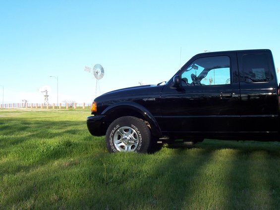 Black 2003 Ford Ranger side view parked in grassy field with windmills