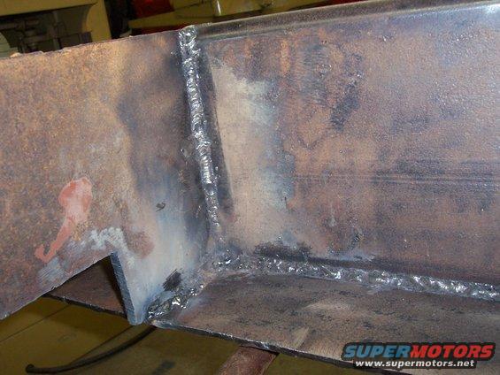 Welded metal frame with rust and burn marks from welding