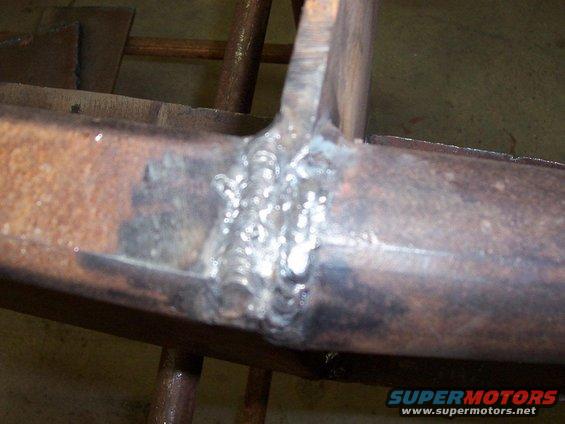 Close-up of a welded metal joint on a rusty frame