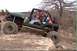 1983 Ford Bronco - This modified Jeep is navigating a rocky obstacle course with a second vehicle in the background.