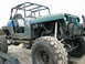 1983 Ford Bronco - This heavily modified Jeep Wrangler features oversized tires, a custom roll cage, and exposed engine components, suggesting it's built for…