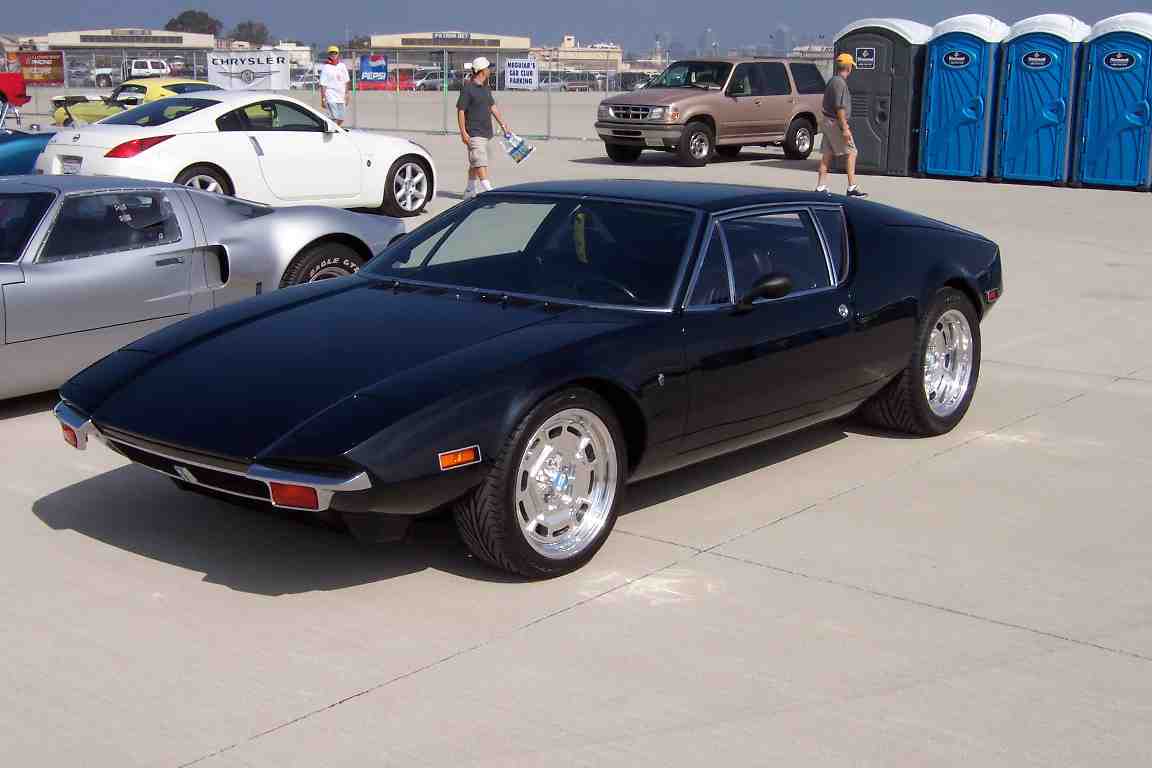 Black sports car with chrome wheels, low profile tires, and pop-up headlights