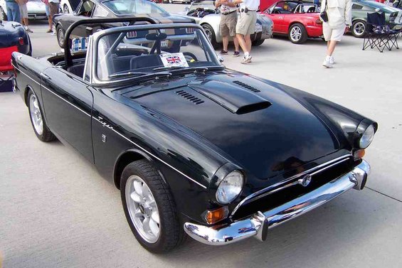 Black convertible sports car with a scoop on the hood and a Union Jack flag on the dashboard