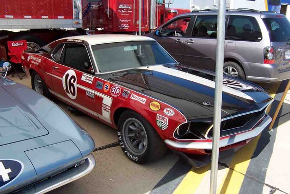 Red and black 1969 racing car with number 16 and racing decals