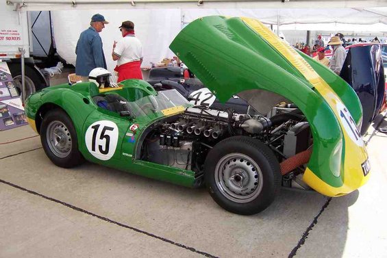 Green and yellow race car, number 15, hood open showing engine