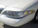 1997 Lincoln Mark VIII - Close-up of the front corner of a white 1997 Lincoln Mark VIII, highlighting the headlight assembly with chrome accents.
