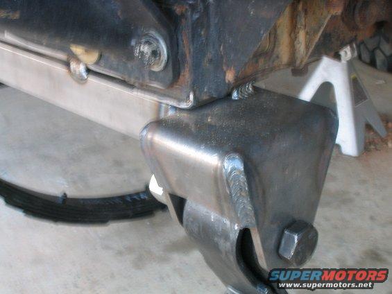 Close-up of a welded metal bracket on a truck's leaf spring suspension