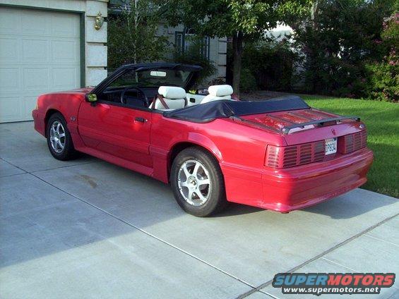 red convertible parked in driveway, top down, white interior