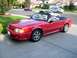 1978 Ford Mustang II - A red convertible with a white interior is parked on a driveway, with other vehicles in the background.