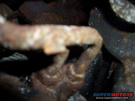 Rusted metal pipe and bracket, close-up view
