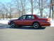 1999 Ford Crown Victoria - Side view of a red sedan with black steel wheels parked outdoors in winter.