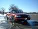 1999 Ford Crown Victoria - A red Ford Crown Victoria is parked outside on a cold, sunny day with patches of snow on the ground.
