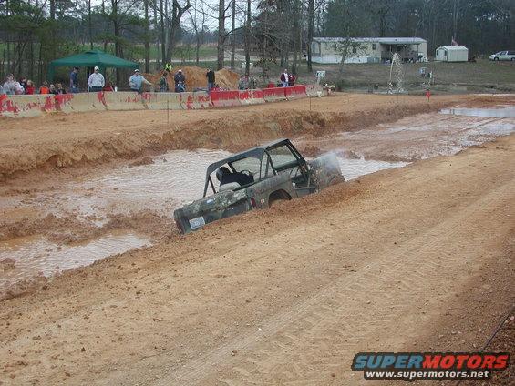 Camouflaged Ford Bronco navigating a mud pit