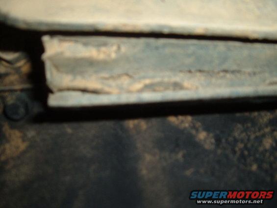 Close-up of a dirty metal frame with visible rust and dirt accumulation
