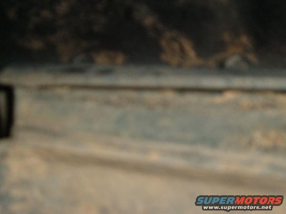 Worn blue paint on vehicle side panel with Supermotors.net watermark