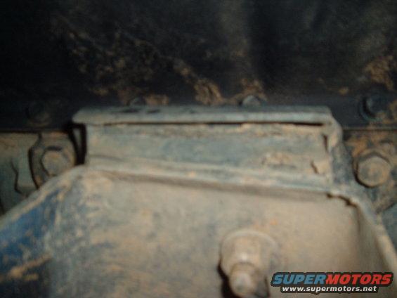 Close-up of a rusty metal frame mount with bolts