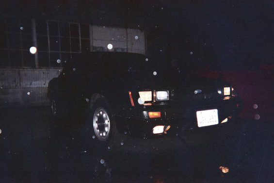 Front view of a black 1985 Ford Mustang at night