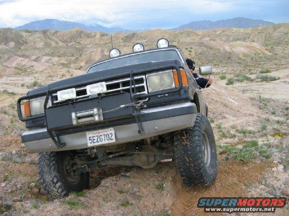 Black SUV with winch and light bar driving off-road