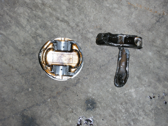 Piston and connecting rod on a concrete surface