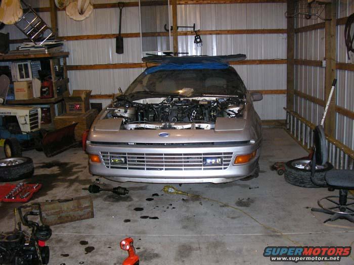 Silver 1990 Ford Probe front view with hood open in garage