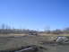 1981 Ford Bronco - A red SUV is stuck in a muddy area under a clear blue sky.