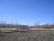 1981 Ford Bronco - A wide, muddy expanse with sparse trees in the background under a bright blue sky.