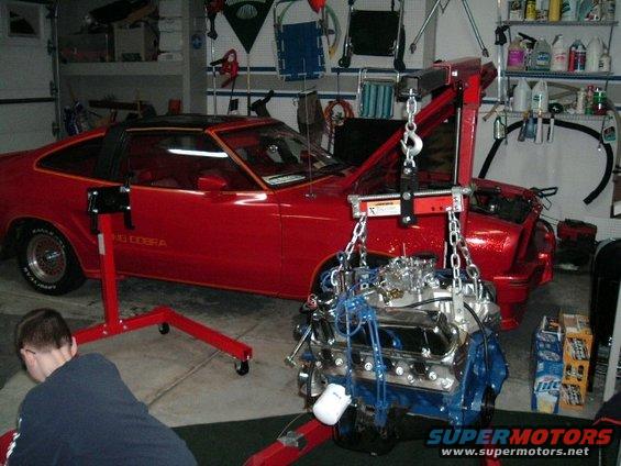 Red 1978 Ford Mustang II with "KING COBRA" text on the side, engine being lifted out