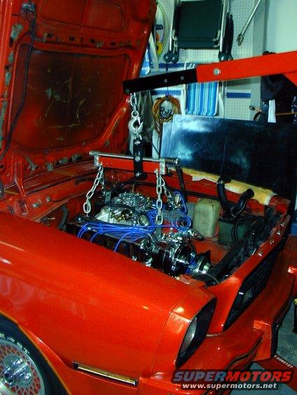 Orange 1978 Ford Mustang II engine bay with engine hoist lifting the engine