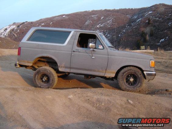 1991 Ford Bronco on a dirt trail, angled up a slope