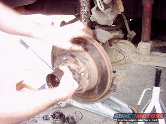 Brake rotor assembly being worked on, showing suspension components